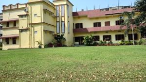 a building with a lawn in front of it at Bequest Stays Celebration in Puri +16 photos