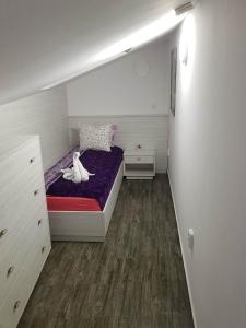 a small bedroom with a bed with a purple mattress at Red House in Kyustendil