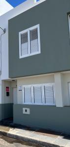 um edifício branco com duas janelas do lado em Casa Reguemar em Arrecife