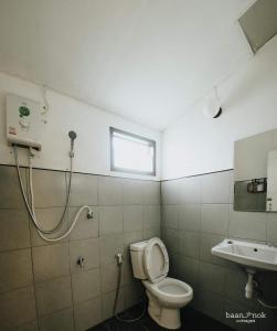 łazienka z toaletą i umywalką w obiekcie Baannok cottages Lamphun w mieście Ban Makok