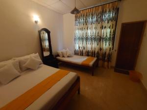 a hotel room with two beds and a mirror at Escape Ella Bungalow in Bandarawela