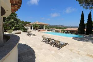 patio z leżakami i basenem w obiekcie villa saint paul w miejscowości Sainte-Maxime