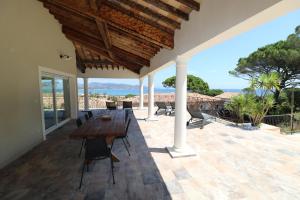 patio z drewnianym stołem i krzesłami na domu w obiekcie villa saint paul w miejscowości Sainte-Maxime