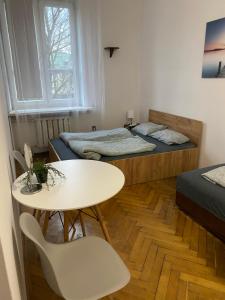 a small room with two beds and a table and chairs at Classy Rooms in Old Town in Krakow