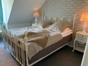 a bedroom with a white bed with two lamps on it at Strandbadsgården B&B in Löderup