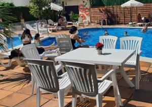 a table and chairs in front of a swimming pool at Hotel Mireia in Lloret de Mar