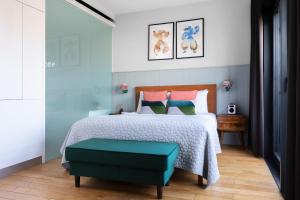 Town Hall Hotel - Shoreditch في لندن: غرفة نوم مع سرير مع مسند أخضر