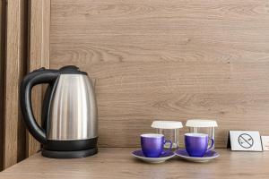 a coffee pot and two cups on a table at Unique Boutique in Bucharest +139 photos