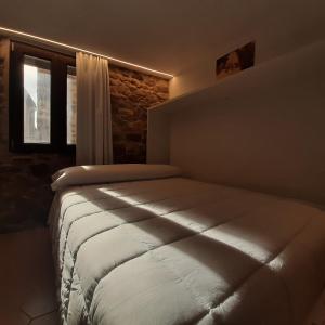 een slaapkamer met een bed in een kamer met een raam bij Casa rural rústica para parejas, familia o amigos a la montaña "EL COLMENAR" in Chóvar