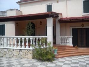a house with a porch and a white railing at L'Arca in Talsano