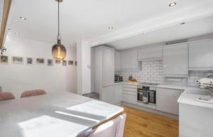 a kitchen with white cabinets and a white counter top at MODERN 3 BED - Sleeps 6 with HOT TUB in Bath