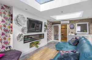 a living room with a blue couch and a tv at MODERN 3 BED - Sleeps 6 with HOT TUB in Bath