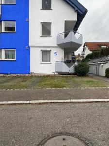 a blue and white building with a balcony on it at Mercedes I Stuttgart I Kitchen I Home Office I Netflix in Böblingen