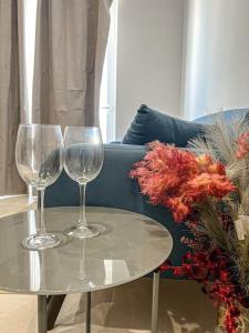 - deux verres à vin sur une table à côté d'un canapé dans l'établissement Serafina's Apartment 5 min walk from St Julians, à San Ġwann