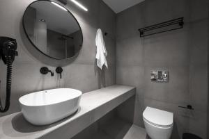 uma casa de banho com um lavatório, um espelho e um WC. em ROTHOS LUXURY em Stavros