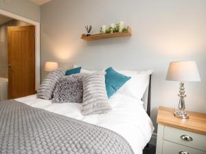 Schlafzimmer mit einem Bett mit weißer Bettwäsche und Kissen in der Unterkunft Ferry View in Fleetwood