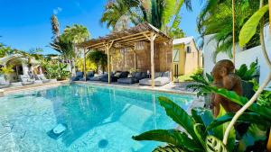 a swimming pool in a villa with palm trees at Île tropical lodges in Sainte-Anne