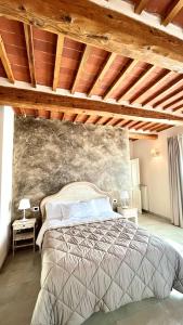 1 dormitorio con 1 cama grande y pared de piedra en Il Podere di Tacito, en Pieve a Nievole