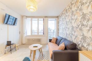 ein Wohnzimmer mit einem Sofa und einem Tisch in der Unterkunft ZenBNB / Sandy / Parking privé / 5 pers. / Géant / in Annemasse
