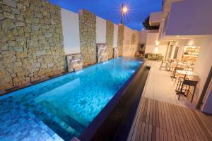 a swimming pool in a villa with a stone wall at Maria Die in Calvi