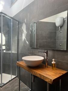een badkamer met een wastafel en een glazen douche bij Little sweet escape in Caserta