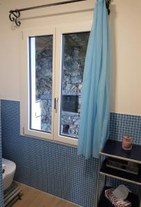 ein Bad mit einem Fenster und einer blau gefliesten Wand in der Unterkunft "Pipistrello" in Ronco sopra Ascona