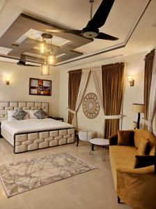 a bedroom with a king sized bed and a couch at Capital Lodges in Islamabad