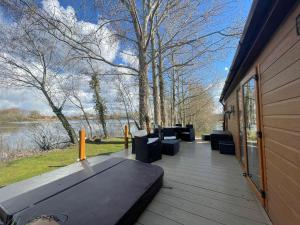 a deck with benches and a view of the water at Rudd lake Luxury lakeside lodge with fishing & hot tub@Tattershall in Tattershall