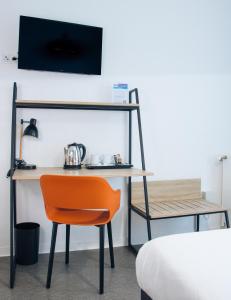 un escritorio con una silla naranja junto a una cama en Twenty Business Flats Maisons Alfort Les Juilliottes, en Maisons-Alfort