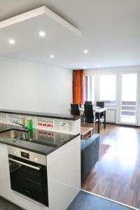 a kitchen with a stove top oven next to a living room at 2.5 Zimmerwohnung für Sportler & Familien WHG 132 & WHG 612 in Täsch