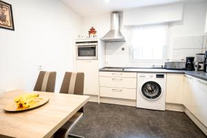 a kitchen with a table and a washing machine at TRUTH für 5 - King Size Betten, Kamin, Garten, XXL Couch, Smart-TV in Dortmund +11 photos