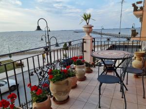 einen Balkon mit einem Tisch, Stühlen und Meerblick in der Unterkunft L'ISOLA AeR B&B in Lesina