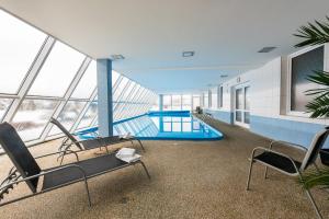 a large building with a swimming pool and chairs at HOTEL AGRI in Soběšice