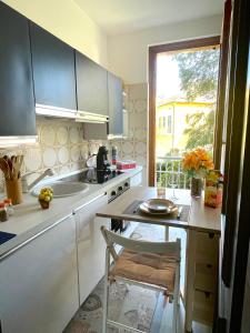 a kitchen with a sink and a counter with a chair at Casa Anna - Parco Hermitage in Porto Valtravaglia