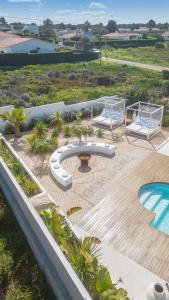 a patio with two chairs and a table and a pool at Villa Sound of the Sea by Portugal Collection in Aljezur