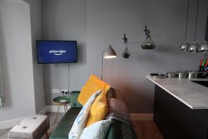 ein Wohnzimmer mit einem Sofa und einem TV an der Wand in der Unterkunft Stylish Margate apartment in Margate