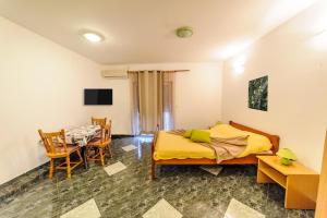 - une chambre avec un lit, une table et des chaises dans l'établissement Apartments & rooms Lucie, à Posedarje