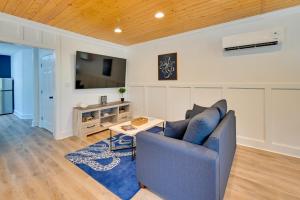a living room with a blue couch and a tv at Chic Studio Near Huntington Beach State Park in Myrtle Beach
