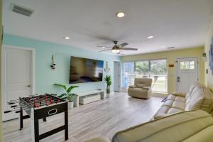 a living room with a ping pong table in the middle at Riverfront Port Orange Home with Dock and Slip! in Port Orange