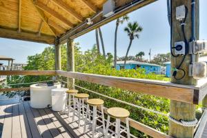 a deck with stools and a trash can at Riverfront Port Orange Home with Dock and Slip! in Port Orange