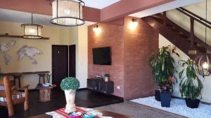 a living room with potted plants and a tv at Hotel Mirador de las Sierras in Villa Carlos Paz