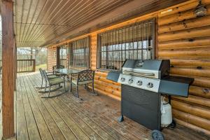 a outdoor kitchen with a grill and a table on a deck at Rustic Cabin in Roaring River State Park! in Eagle Rock