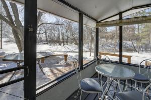a screened in porch with a table and chairs and snow at Home Rental on Detroit Lake Dock, Game Room! in Detroit Lakes