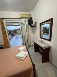 1 dormitorio con cama, escritorio y espejo en Δειλινά, en Plati