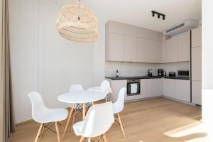 una cucina e una sala da pranzo con tavolo e sedie bianchi di 4bdr Modern and Stylish Apartment near Kadriorg with Free Parking a Tallinn