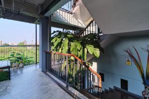 a balcony with a plant on the side of a building at Bkk39 Airport hotel in Ban Khlong Prawet