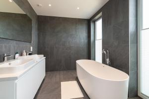 a bathroom with a white tub and a sink at 4bdr Modern and Stylish Apartment near Kadriorg with Free Parking in Tallinn
