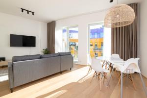 a living room with a couch and a table and chairs at 4bdr Modern and Stylish Apartment near Kadriorg with Free Parking in Tallinn