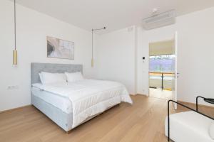 a white bedroom with a bed and a window at 4bdr Modern and Stylish Apartment near Kadriorg with Free Parking in Tallinn