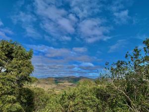 Elle offre une vue sur les arbres et les montagnes sous un ciel bleu. dans l'établissement August de Saint Hilaire/ Reserva Alto da Colina, à Conceição da Ibitipoca